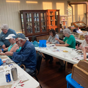 men and women in a jewelry-making class